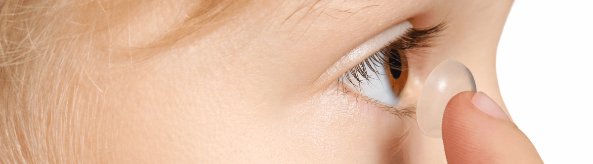 Close up of child putting in contact lense 