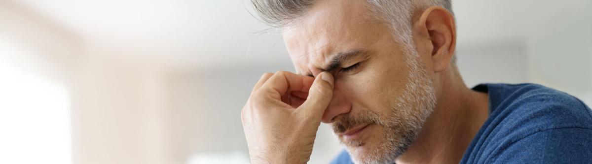 man pinching nose due to headache from eyestrain