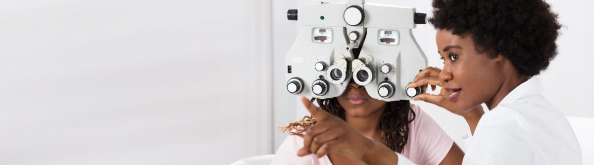 optometrist performing eye exam on young female